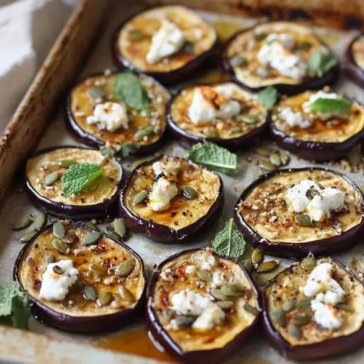 Berenjena Asada con Miel, Queso de Cabra y Semillas de Calabaza: Un Manjar en Cada Bocado